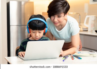 At-home Learning, New Normal Daily Routine For Kids. A Smart Asian Boy Using Laptop Computer To Study From Home During Covid-19 Pandemic Lockdown With His Mother. Online Education, Homeschooling.