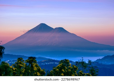 Atitlan Volcano with an altitude of 3,535 m in front of the lake of Atitlan in Guatemala, landscape at sunrise panoramic mountainous and green, green tourism.