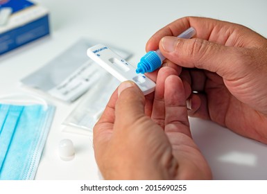  ATK SARS Cov 2 coronavirus rapid antigen test nasal kit. A man doing Covid-19 Self test at home. Hand holding test on white background. Antigen rapid test kit of Covid-19 for selftest at home.
