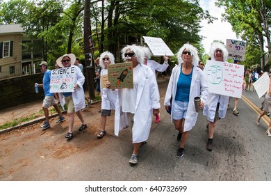 ATLANTA, GA - APRIL 22: A Group Of Women Dressed Like Albert Einstein Hold Up Signs As They Walk In The Atlanta March For Science Near Candler Park On Earth Day On April 22, 2017 In Atlanta, GA.