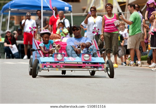 
ATLANTA, GA - AUGUST 3:  A father and daughter steer their homemade
car down a hilly street in the Cool Dads Rock Soap Box Derby, held
at the Old 4th Ward Park on August 3, 2013 in Atlanta.
