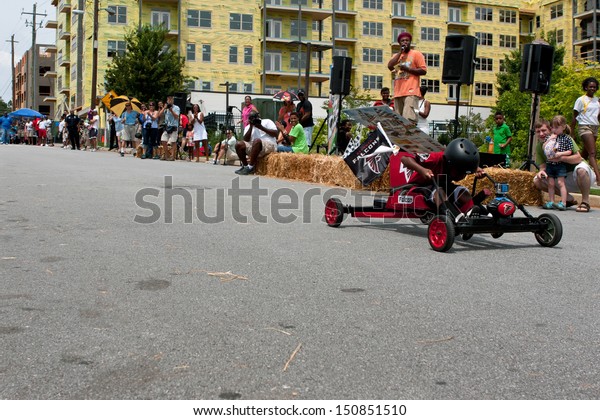 ATLANTA, GA\
- AUGUST 3:  An unidentified kid steers his car down a street as\
onlookers cheer in the Cool Dads Rock Soap Box Derby, at the Old\
4th Ward Park on August 3, 2013 in Atlanta. \
