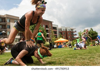 ATLANTA, GA - JULY 16: Two women play leap frog, one of many children's games played by teams at the Atlanta Field Day event at the Old Fourth Ward Park on July 16, 2016 in Atlanta, GA. 