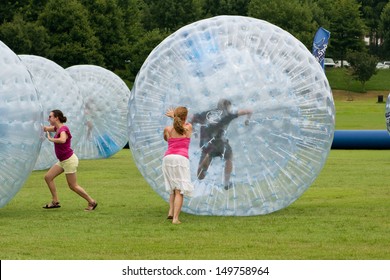 ATLANTA, GA - JULY 27:  Women push young people around in rolling zorbs at the 3rd Annual Atlanta Ice Cream Festival at Piedmont Park, on July 27, 2013 in Atlanta.   