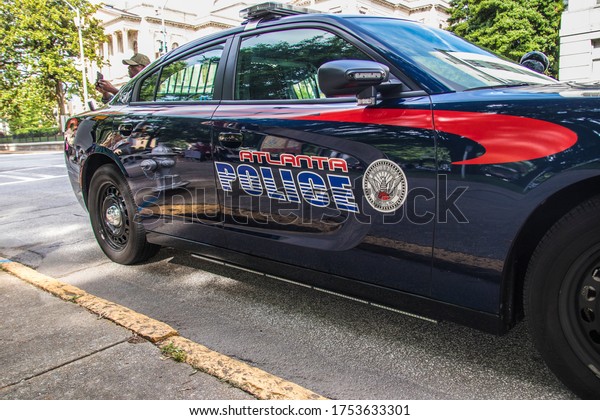 Atlanta, Ga  USA - 06 07 20: Atlanta police car and\
officer on cellphone 
