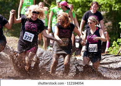 ATLANTA, GA , USA - APRIL 28, 2012:  A Group Of Unidentified Women Competing In The Dirty Girl Mud Run, Splash Through Mud As They Near The Finish Line Of The Women Only Race On April 28, 2012 In Atlanta.