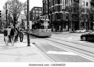 Atlanta, GA / USA - April 8, 2019: Streetcar Passing People Walking Down Street.