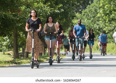 Atlanta, GA / USA - July 6, 2019:  Various people ride motorized scooters along the Atlanta Belt Line at the Old Fourth Ward Park, on July 6, 2019 in Atlanta, GA.