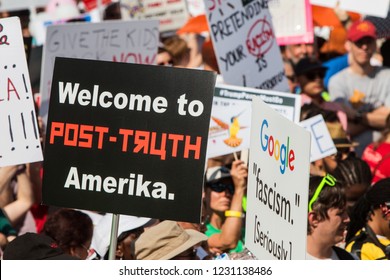 Atlanta, GA/ USA - June 30 2018:  A sign reading "Welcome to post-truth Amerika" stands out among other signs at an immigration law protest and march on June 30, 2018 in Atlanta, GA.
