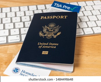 ATLANTA, GEORGIA - AUGUST 21, 2019 : United States Of America Passport With Department Of Homeland Security TSA Pre Check Registration Information Card. US Passport On Desk With Computer Keyboard.