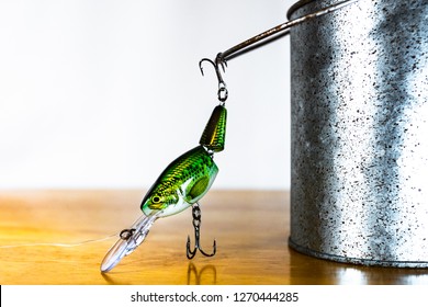 ATLANTA, GEORGIA - DECEMBER 29, 2018 : Fishing Lure Hanging From Metal Minnow Bucket Handle. Bass Fishing Tackle Including Crank Bait Lure With White And Wood Background.