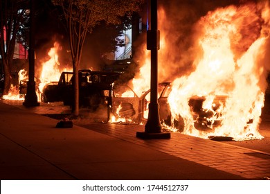 ATLANTA, GEORGIA - MAY 29, 2020: Police cars in flames during the protests in Atlanta over the slaying of George Floyd.