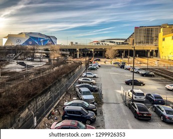 ATLANTA, GEORGIA / USA - January 30, 2019: Cars Parked At The Gulch And Rail Yard Overlooking CNN World Headquarters, State Farm Arena, And Mercedes-Benz Stadium Hosting NFL Super Bowl 53.