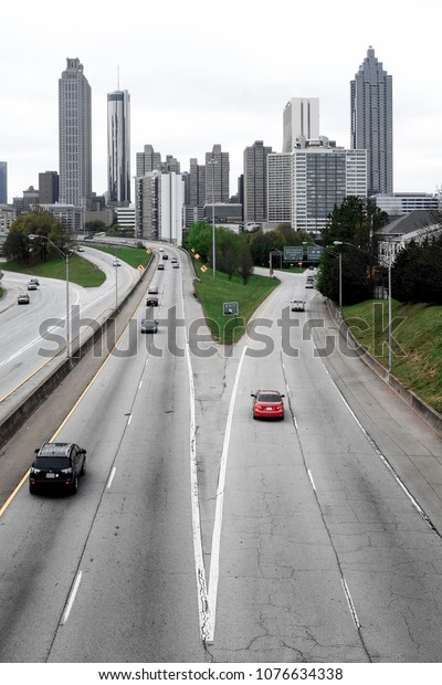Atlanta\
skyline with a turnpike and high way traffic in the foreground\
toned black and white photograph, vertical\
format
