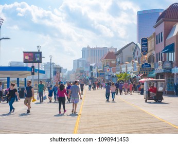 ATLANTIC CITY, NEW JERSEY - MAY 21, 2018: Tourists walk on the boardwalk in Atlantic City.