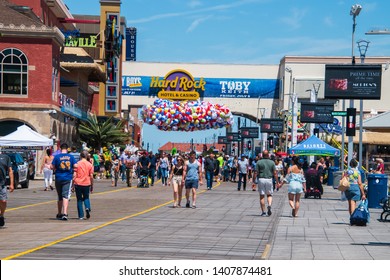 Atlantic City, New Jersey - May 24, 2019: Boardwalk view with tourists strolling. There is a huge bag of beach balls suspended over the boardwalk to celebrate the annual Beach Ball Drop