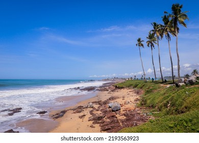 Atlantic Ocean Coastline With The Turquoise Waves Among The Palm Trees In Elmina City In Ghana, West Africa