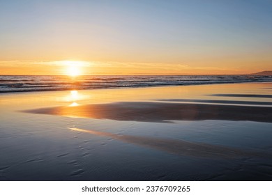 Atlantic ocean sunset with surging waves at Fonte da Telha beach, Costa da Caparica, Portugal