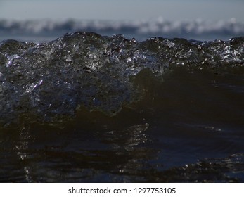 Atlantic ocean wave close up, drops of water sprinkle near the shore.
