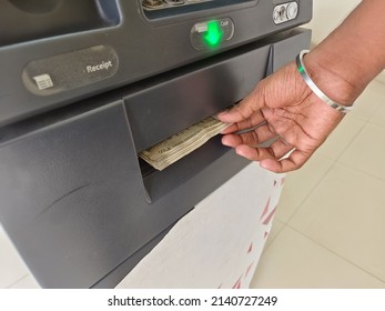 ATM Cash withdrawal - Indian rupees in ATM. Man withdrawing the cash via ATM, business Automatic Teller Machine concept.