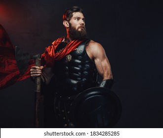 Atmospheric and dark room with spotlight and roman guardian with muscular build and beard holding axe and shield whihc posing in it.