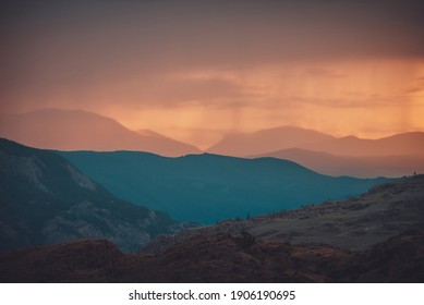 Atmospheric landscape with silhouettes of mountains with trees on background of orange dawn sky. Colorful nature scenery with sunset or sunrise. Sundown paysage in vintage colors and faded tones. - Shutterstock ID 1906190695