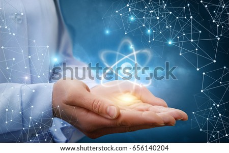 Atom molecule in female hands on a blue background.