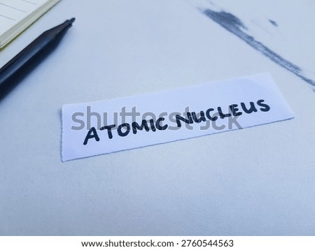 Atomic nucleus writting on table background. 