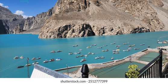 Attabad Lake, located in Hunza, Pakistan, is a stunning turquoise lake formed in 2010 after a landslide. Surrounded by majestic mountains, it offers breathtaking views, boating, and a serene natural e - Powered by Shutterstock