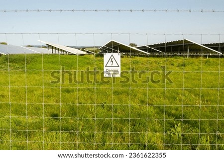 Attached to the barbed wire security fence,surrounding an area of solar panels,at a remote rural locaton in the Cotswolds area of the English countryside,on a bright summer afternoon.