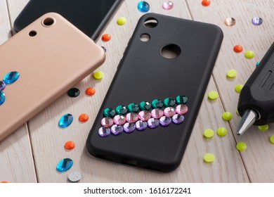 Attaching Colorful Rhinestones Onto Phone Cases With A Glue Gun. Amazing DIY Project For Young Fashionista.