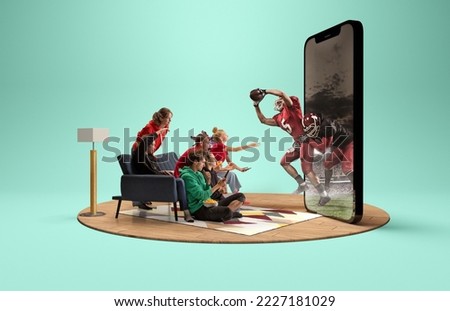 Attack. Group of young excited friends watching american football match at home interior. Huge 3D model of phone screen with created presence effect of american football players in action