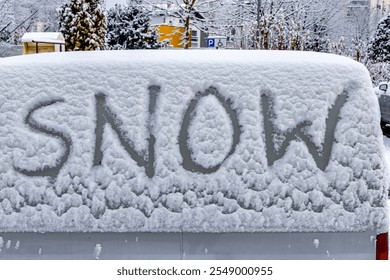 The attack of winter, the first snowfall, the word snow written on the car body in the snow