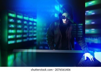 An attacker penetrates server - concept. Hacker breaks into server hardware. Hacking telecommunications company. Network attack on data center. Hacker man next to server racks. Art focus - Powered by Shutterstock - Get 15% off with code: PIKWIZARD15