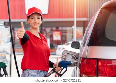 Attendant service female worker refuelling car at gas station. Assistant woman worker wear red uniform and red hat refuelling car at petrol station - Shutterstock ID 2240721211