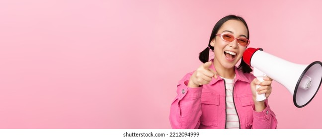 Attention, Announcement Concept. Enthusiastic Asian Girl Shouting In Megaphone, Advertising With Speaker, Recruiting, Standing Over Pink Background