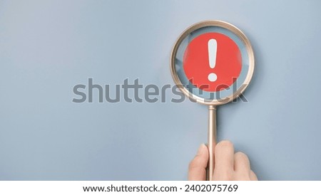 Attention caution warning concept. Magnifying glass focus on red page with exclamation error mark for important alert signal, Hazard, risk ,danger background with copyspace.
