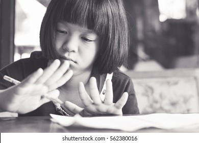 Attention deficit hyperactivity disorder (ADHD) and Learning Disability (LD) in children and teens concept. Asia kid girl student doing compute homework using finger to calculate.Homeschool Education.