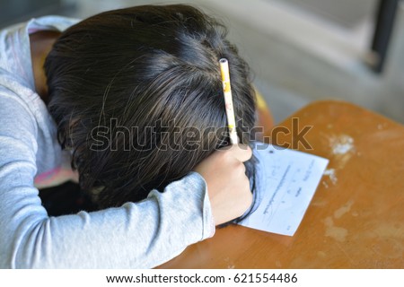 Attention deficit hyperactivity disorder (ADHD) and Learning disability (LD) in children and teens concept.Female cute child asleep on paper.Asian students sleeping while practice math subject at home