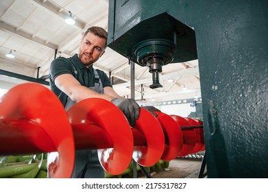 Attention To Detail. Man In Uniform Is In Workstation Developing Parts Of Agriculture Technique.