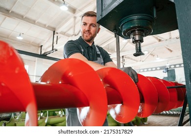 Attention To Detail. Man In Uniform Is In Workstation Developing Parts Of Agriculture Technique.