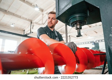 Attention To Detail. Man In Uniform Is In Workstation Developing Parts Of Agriculture Technique.