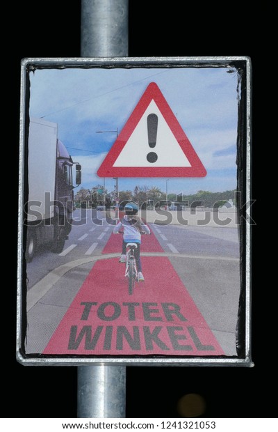 Attention sign with the German inscription: Blind\
Spot or Dead Corner (Toter Winkel) at the Bike Flash warning system\
to warn right-turning trucks - city of Garbsen, Hanover district,\
Germany