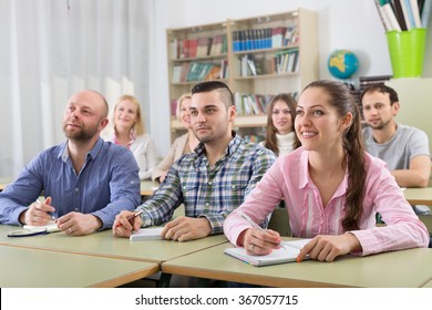 Attentive Adult Students Industriously Writing Down Summary In A Classroom 