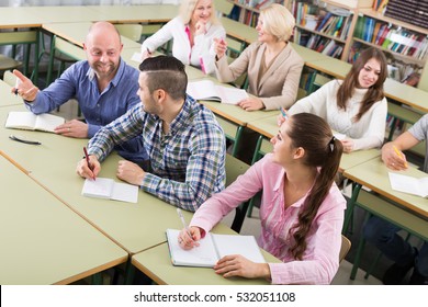 Attentive Adult Students Writing Down Summary At Classroom 