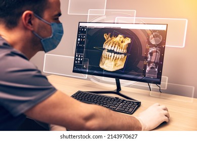 Attentive dentist examining an x-ray on computer in dental clinic - Powered by Shutterstock