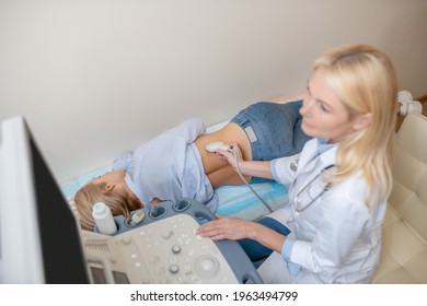 Attentive Female Doctor Performing Kidney Ultrasound Scan And Patient