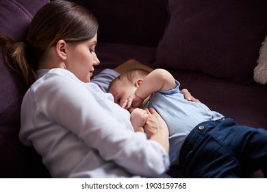 Attensive weibliche Person, die ihren Sohn während der Stillzeit streichelt