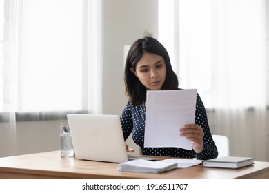 Attentive Millennial Asian Female Holding Paper Letter Document Reading Financial Statement. Focused Vietnamese Business Woman Worker Employee Review Offer Proposal Study Job Contract Terms Conditions