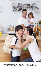 Attentive Mother Giving School Lunch To Her Son In The Kitchen